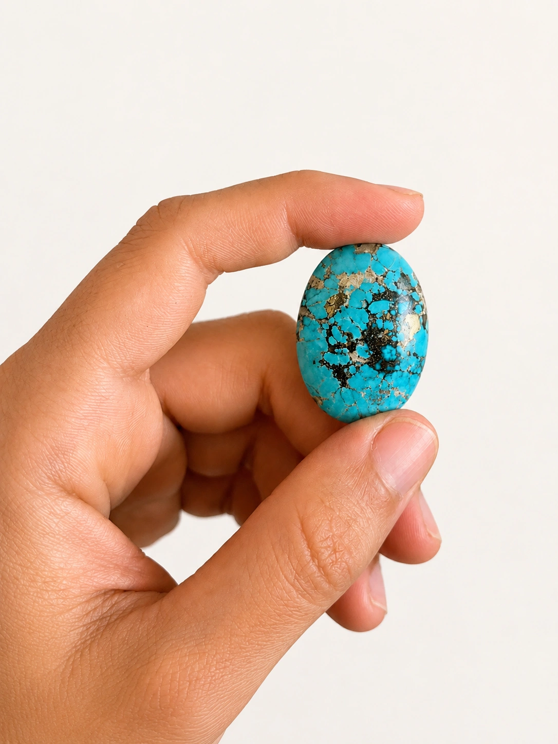 NEYFI 1005 natural Persian spiderweb turquoise oval cabochon, hand-scale view